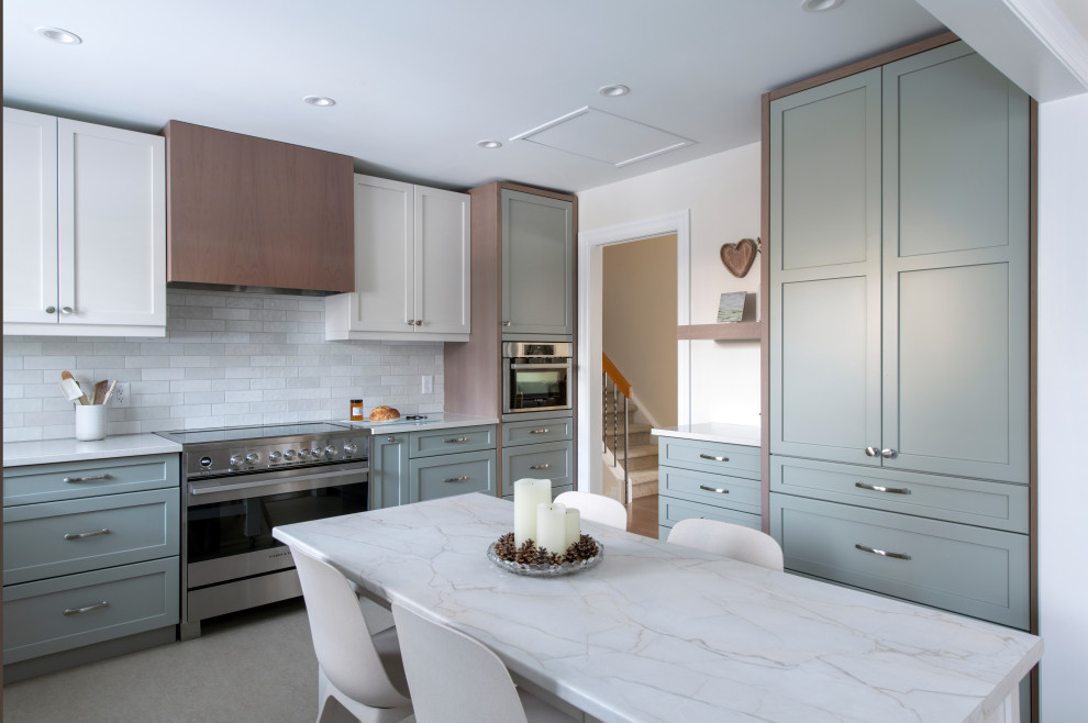 Example of a mid-sized transitional u-shaped linoleum floor and gray floor eat-in kitchen design in Ottawa with a farmhouse sink, shaker cabinets, gray cabinets, quartz countertops, white backsplash, subway tile backsplash, stainless steel appliances, an island and white countertops