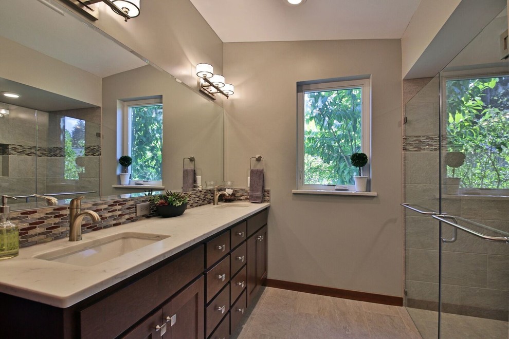 Photo of a mid-sized modern master bathroom in Seattle with shaker cabinets, medium wood cabinets, a freestanding tub, an alcove shower, a two-piece toilet, mosaic tile, beige walls, porcelain floors, an undermount sink and marble benchtops.