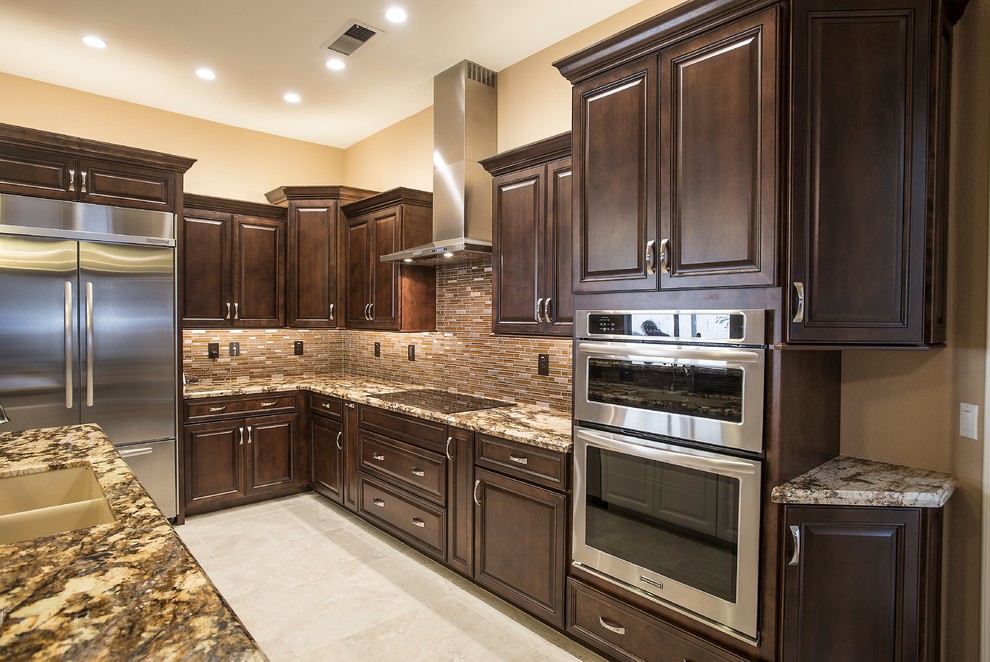 Inspiration for a mid-sized transitional l-shaped ceramic tile open concept kitchen remodel in Phoenix with an undermount sink, raised-panel cabinets, dark wood cabinets, granite countertops, brown backsplash, glass tile backsplash, stainless steel appliances and an island