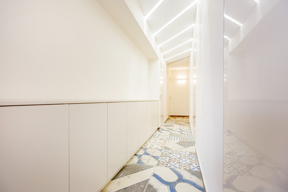 На фото: коридор среднего размера в стиле лофт с белыми стенами, полом из керамогранита, разноцветным полом, многоуровневым потолком и обоями на стенах с