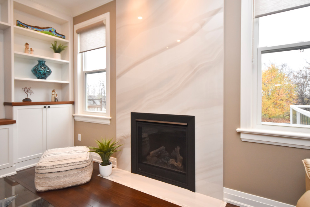 This is an example of a contemporary living room in Ottawa with a tile fireplace surround and a built-in media wall.