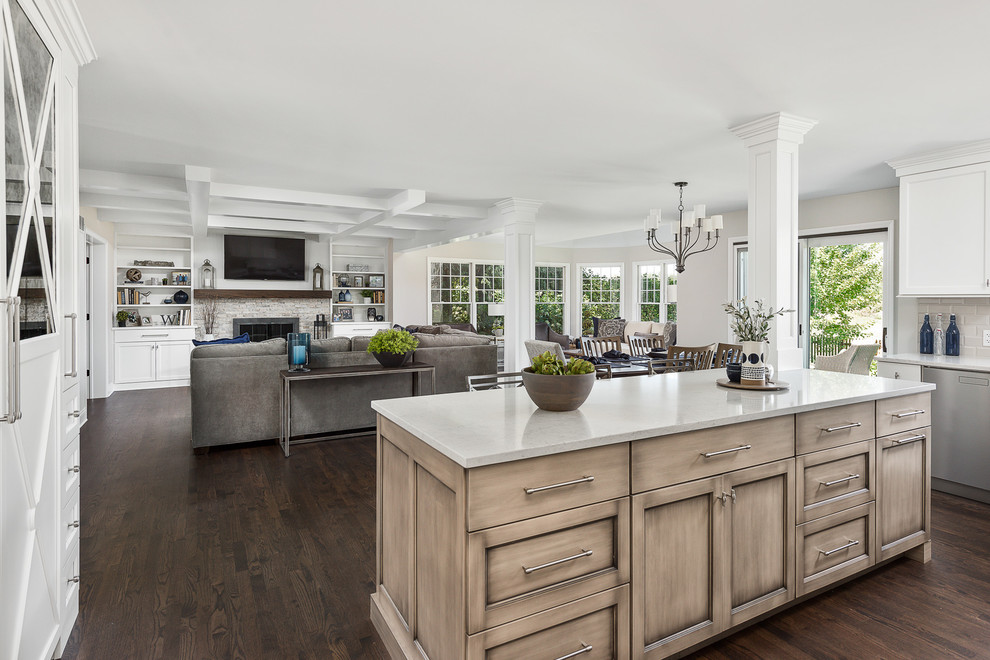 Inspiration for a large transitional l-shaped open plan kitchen in Chicago with flat-panel cabinets, white cabinets, quartz benchtops, grey splashback, ceramic splashback, stainless steel appliances, dark hardwood floors, with island, brown floor and white benchtop.
