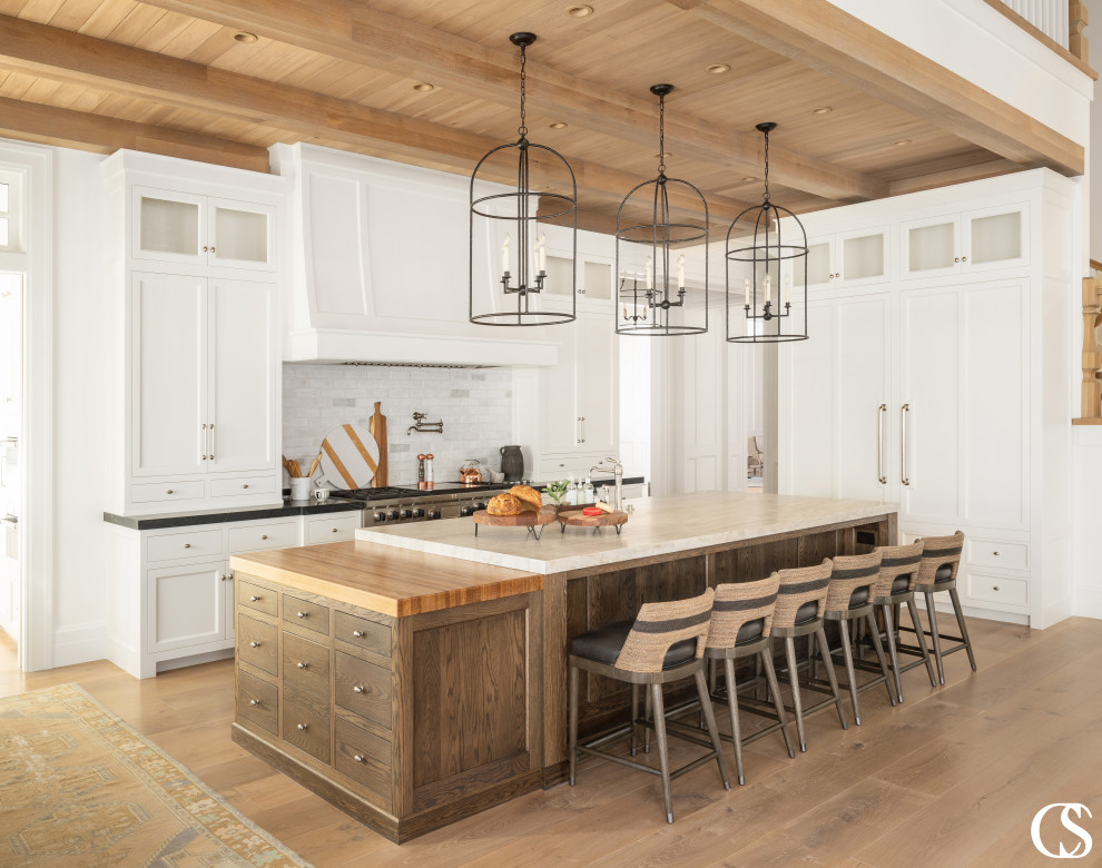 Photo of a large traditional open plan kitchen in Salt Lake City with shaker cabinets, white cabinets, soapstone worktops, integrated appliances, medium hardwood flooring, an island and a wood ceiling.