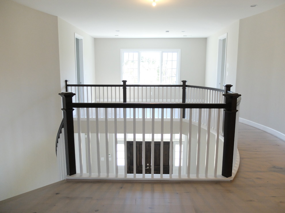 Inspiration for a transitional wooden curved light wood floor hallway remodel in DC Metro with beige walls