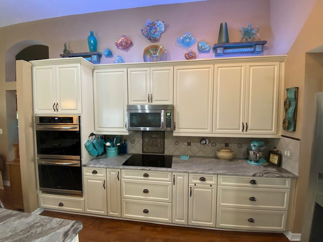 Example of a large galley eat-in kitchen design with raised-panel cabinets, beige cabinets and an island