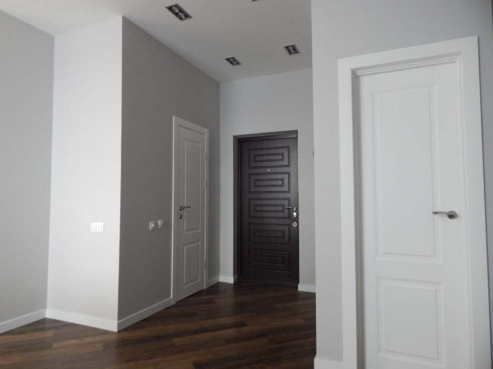 Стильный дизайн: входная дверь среднего размера: освещение с серыми стенами, полом из ламината, одностворчатой входной дверью, входной дверью из темного дерева, коричневым полом и обоями на стенах - последний тренд