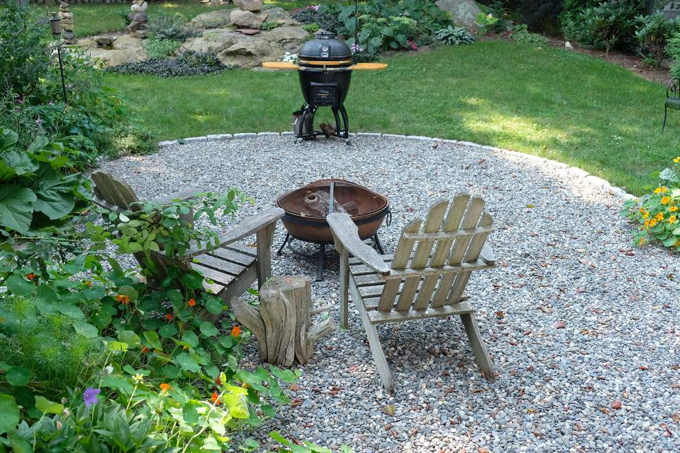 Inspiration for a small contemporary backyard partial sun xeriscape for summer in Boston with a fire feature and gravel.