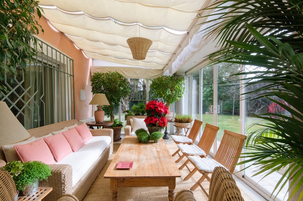 Large traditional backyard verandah in Madrid with an awning.