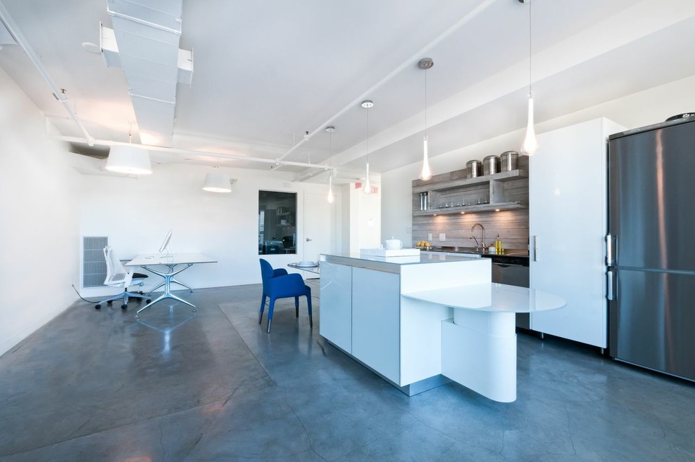 Inspiration for a modern single-wall eat-in kitchen in Vancouver with an integrated sink, flat-panel cabinets, white cabinets, glass benchtops, grey splashback, stainless steel appliances, concrete floors and with island.