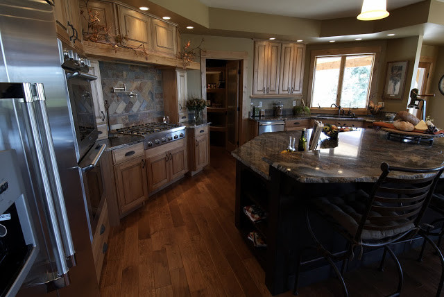 Inspiration for a large rustic u-shaped medium tone wood floor open concept kitchen remodel with a double-bowl sink, beaded inset cabinets, medium tone wood cabinets, granite countertops, stainless steel appliances and an island