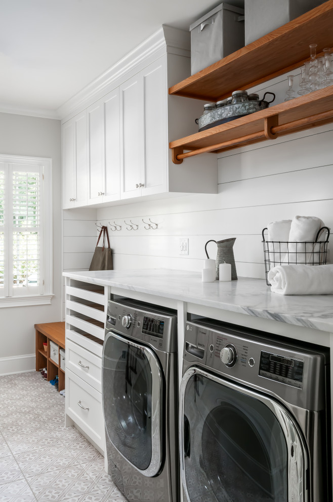 Photo of a traditional utility room in Atlanta with an undermount sink, shaker cabinets, white cabinets, marble benchtops, grey walls, ceramic floors, a side-by-side washer and dryer, grey floor and white benchtop.
