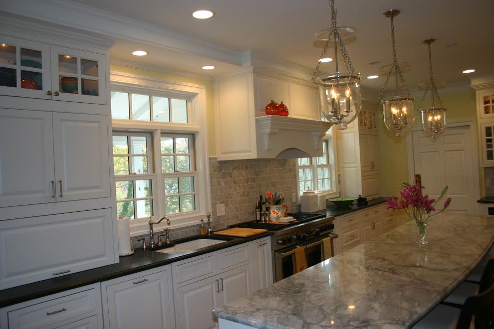 Eat-in kitchen - large transitional u-shaped dark wood floor eat-in kitchen idea in Baltimore with a double-bowl sink, raised-panel cabinets, light wood cabinets, granite countertops, black backsplash, ceramic backsplash, stainless steel appliances and no island
