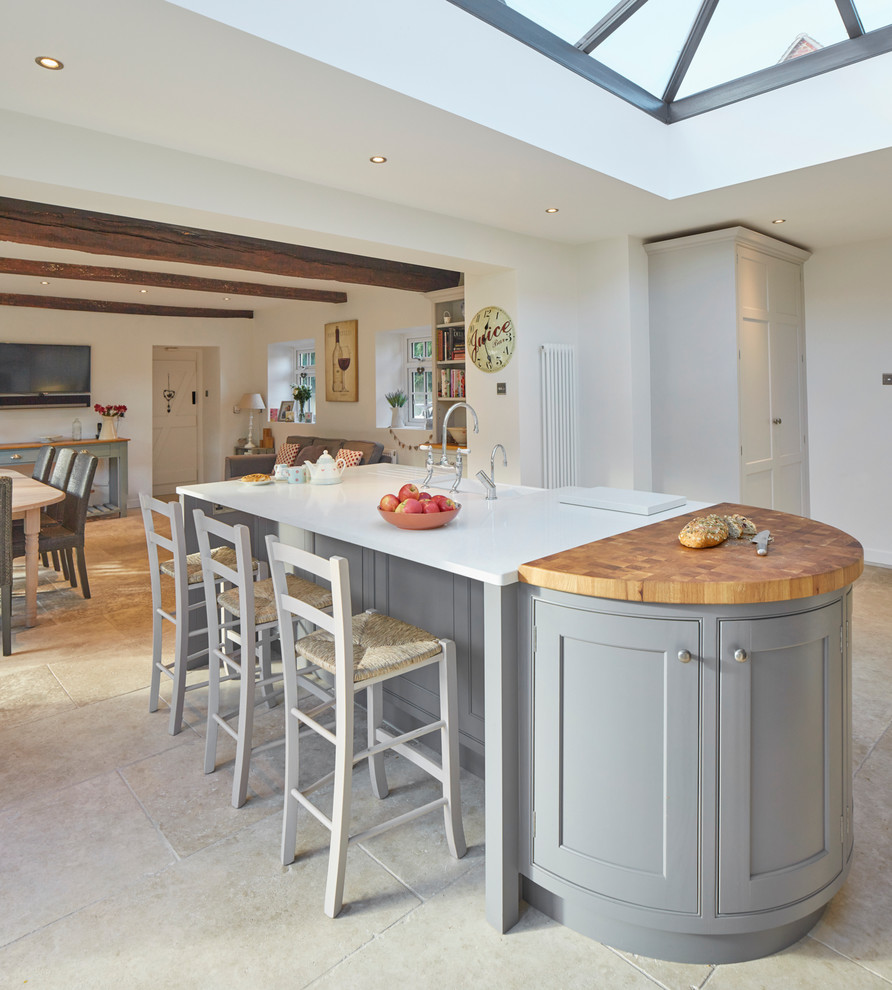 Design ideas for a large country eat-in kitchen in Wiltshire with a farmhouse sink, recessed-panel cabinets, grey cabinets, quartz benchtops, beige splashback, stone slab splashback, stainless steel appliances, limestone floors and a peninsula.