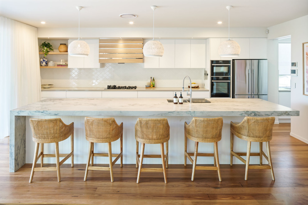 Beach style medium tone wood floor and brown floor kitchen photo in Sunshine Coast with an undermount sink, marble countertops, white backsplash, porcelain backsplash, stainless steel appliances and multicolored countertops