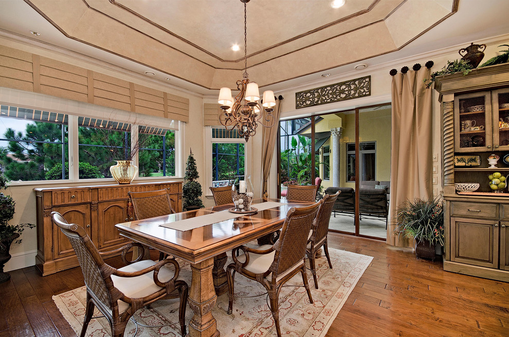 Photo of a mediterranean dining room in Miami with beige walls, medium hardwood floors and no fireplace.
