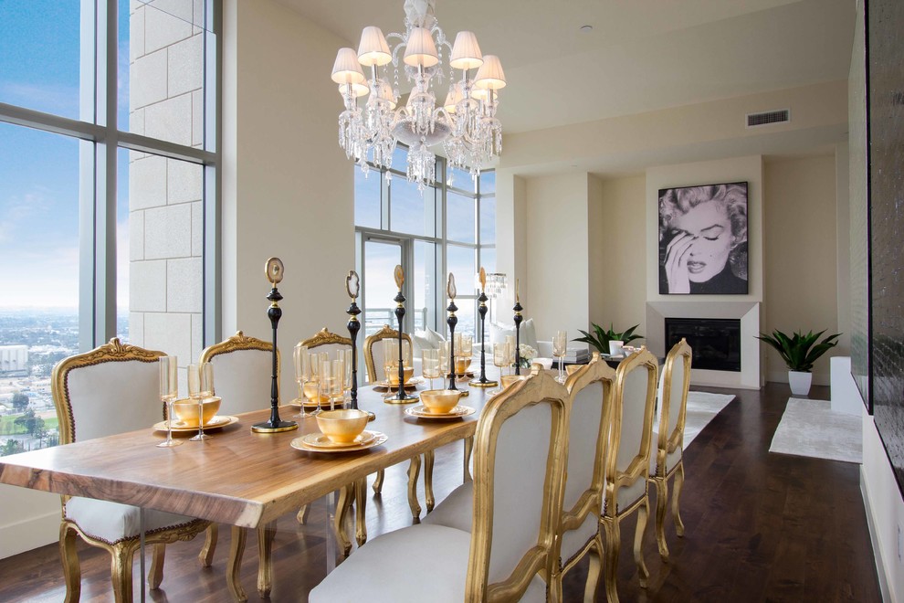 This is an example of a large contemporary kitchen/dining combo in Los Angeles with white walls, medium hardwood floors, a standard fireplace and a stone fireplace surround.