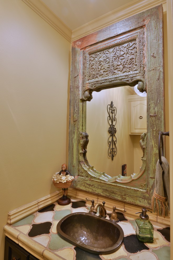 Small country powder room in Houston with raised-panel cabinets, black cabinets, a two-piece toilet, multi-coloured tile, ceramic tile and beige walls.