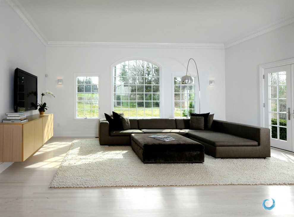 Inspiration for a large modern open concept light wood floor family room remodel in New York with white walls, no fireplace and a wall-mounted tv