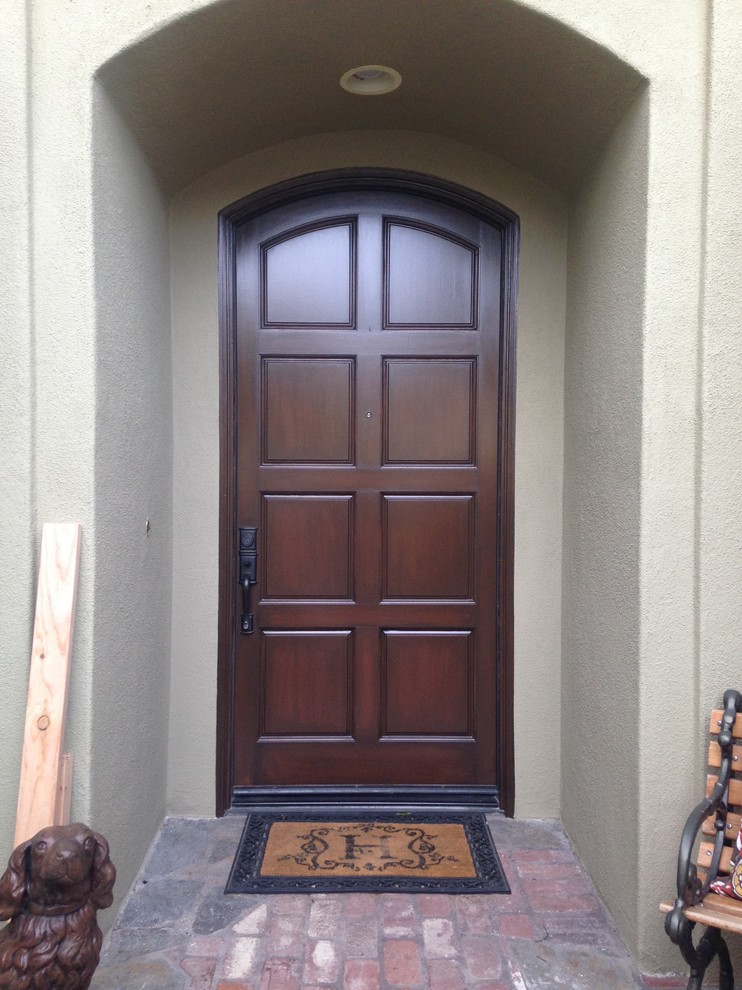 Inspiration for a small arts and crafts front door in Orange County with a single front door and a dark wood front door.
