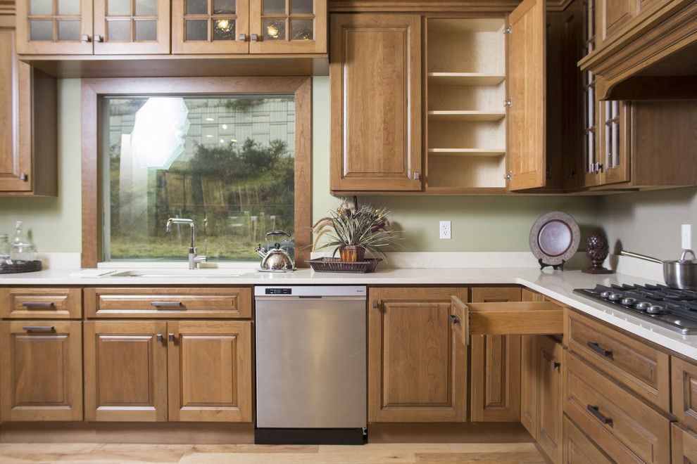 Photo of an expansive traditional l-shaped eat-in kitchen in Seattle with an undermount sink, raised-panel cabinets, medium wood cabinets, quartz benchtops, beige splashback, stone slab splashback, stainless steel appliances and medium hardwood floors.