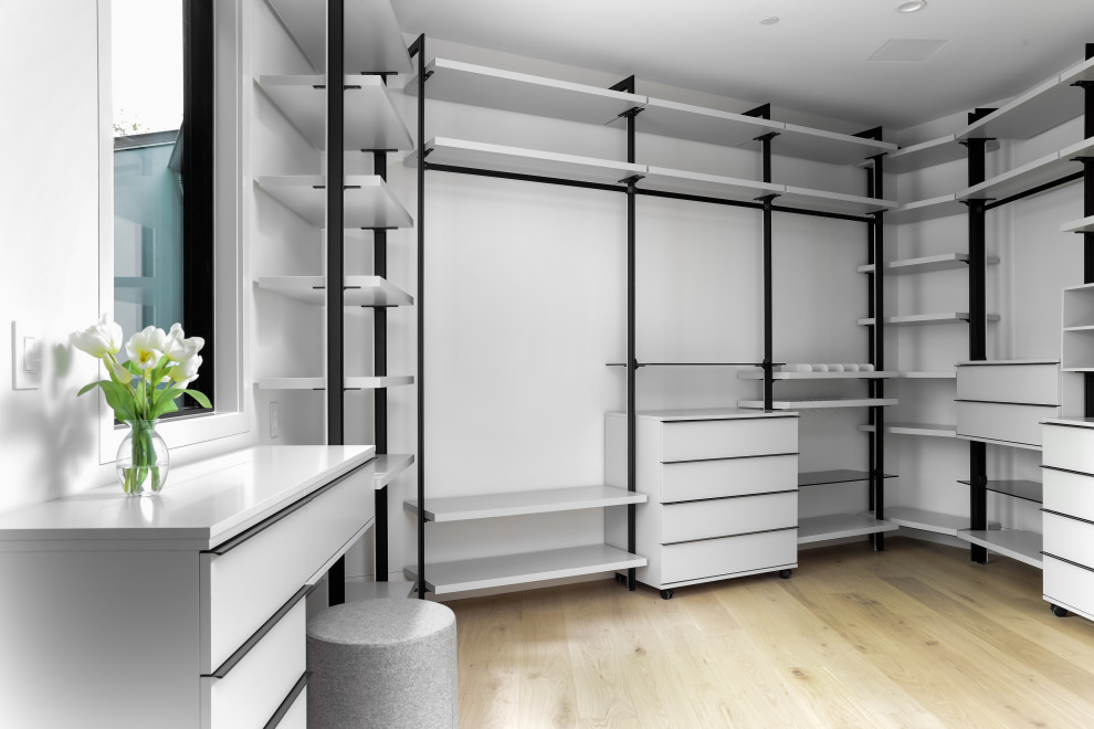 Inspiration for a large modern gender neutral walk-in wardrobe in Austin with open cabinets, white cabinets, medium hardwood flooring, brown floors and a drop ceiling.