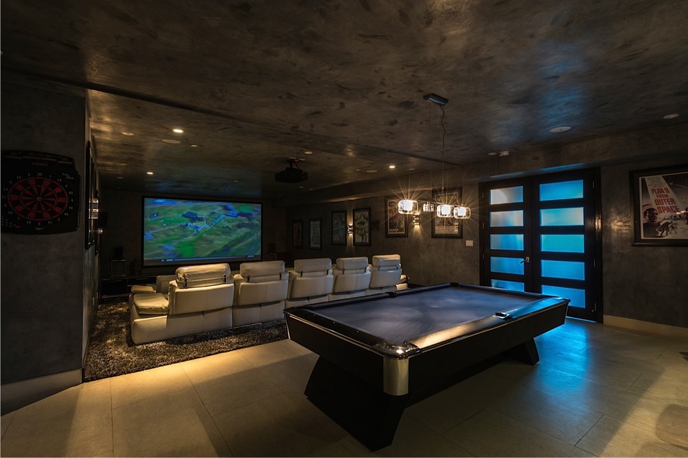 Photo of a mid-sized open concept home theatre in Los Angeles with grey walls, travertine floors, a projector screen and beige floor.