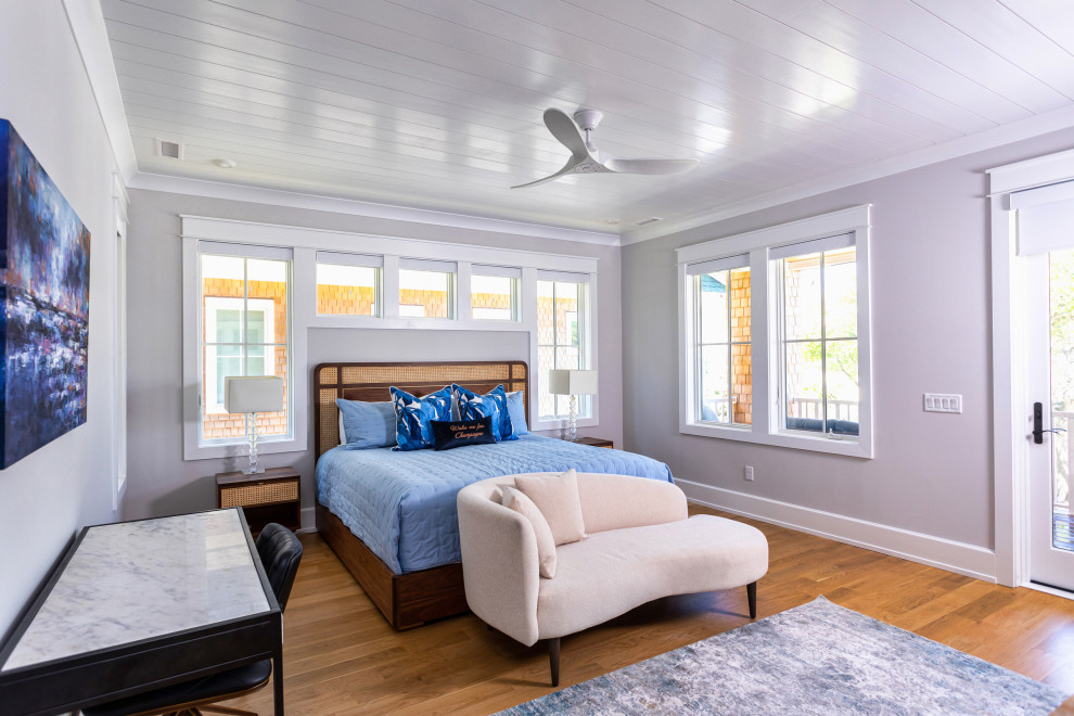 Foto di un'ampia camera degli ospiti stile marino con pareti bianche, pavimento in legno massello medio e pavimento marrone