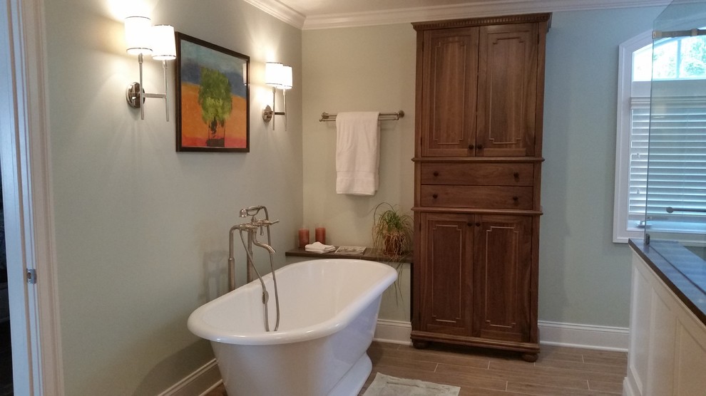 Large country master bathroom in New York with an undermount sink, beaded inset cabinets, medium wood cabinets, wood benchtops, a freestanding tub, a double shower, a two-piece toilet, green tile, stone slab, green walls and porcelain floors.