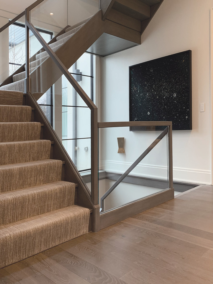 Источник вдохновения для домашнего уюта: большая п-образная лестница в стиле модернизм с ступенями с ковровым покрытием, ковровыми подступенками и стеклянными перилами