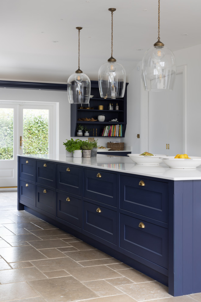 This is an example of a large traditional kitchen in Hampshire with shaker cabinets, blue cabinets, quartz benchtops, metallic splashback, with island and white benchtop.