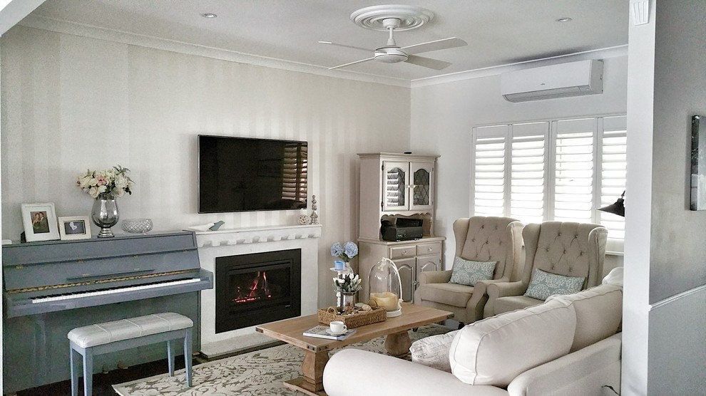 This is an example of a small traditional open concept living room in Sydney with white walls, dark hardwood floors, a standard fireplace, a brick fireplace surround and a wall-mounted tv.