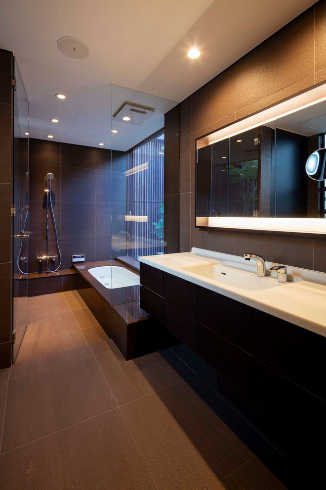 Design ideas for a modern bathroom in Osaka with flat-panel cabinets, brown cabinets, a drop-in tub, an open shower, black walls, an integrated sink, grey floor and an open shower.