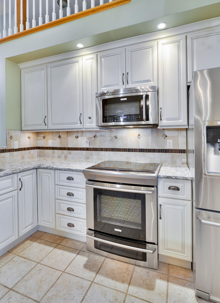 Mid-sized transitional galley open concept kitchen photo with a double-bowl sink, beaded inset cabinets, white cabinets, wood countertops, beige backsplash, ceramic backsplash, stainless steel appliances and a peninsula