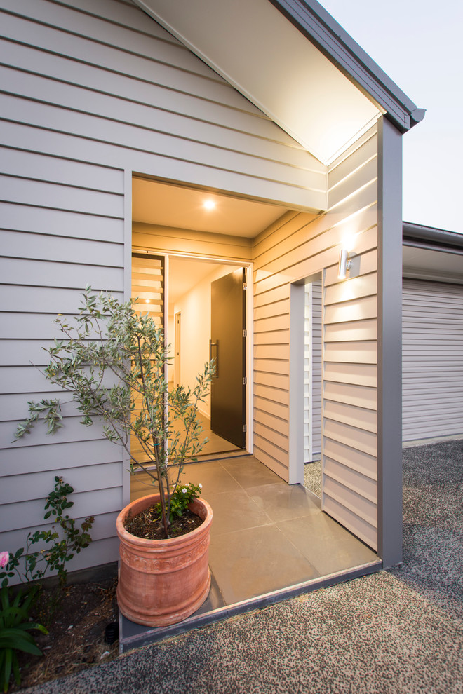 Photo of a mid-sized contemporary front door in Brisbane with grey walls, porcelain floors, a single front door and a black front door.