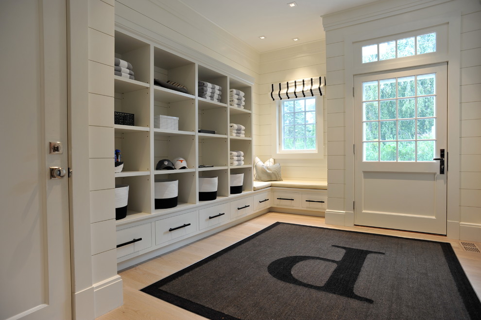 Design ideas for a beach style mudroom in New York with white walls, light hardwood floors, a single front door and a white front door.
