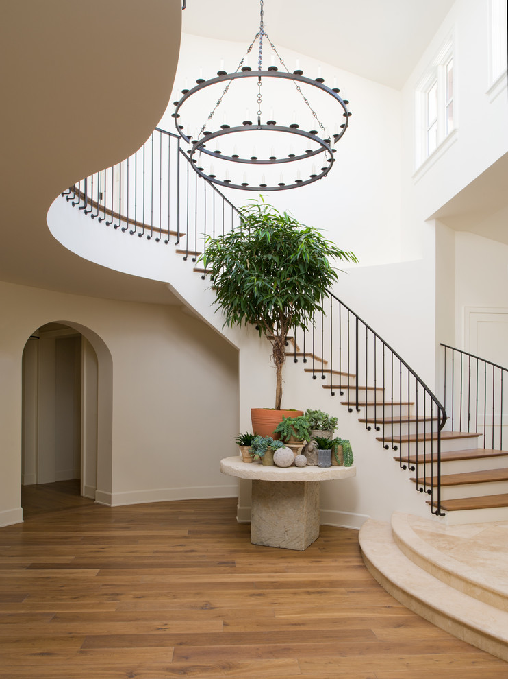 Photo of a mediterranean wood staircase in Los Angeles with painted wood risers and metal railing.