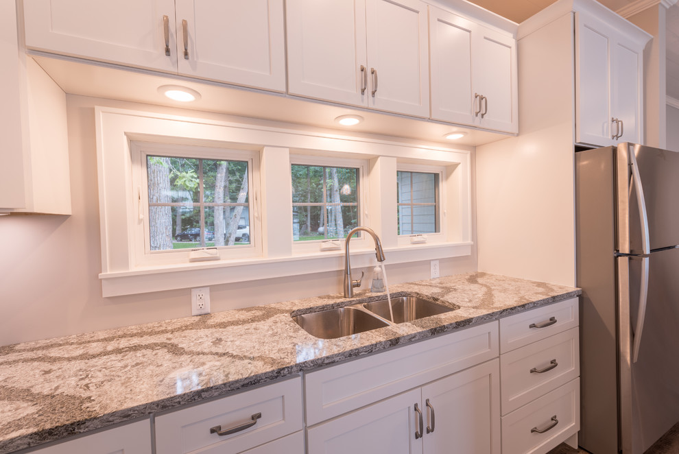Inspiration for a mid-sized transitional l-shaped eat-in kitchen in Minneapolis with an undermount sink, shaker cabinets, white cabinets, quartz benchtops, grey splashback, vinyl floors, with island and multi-coloured benchtop.