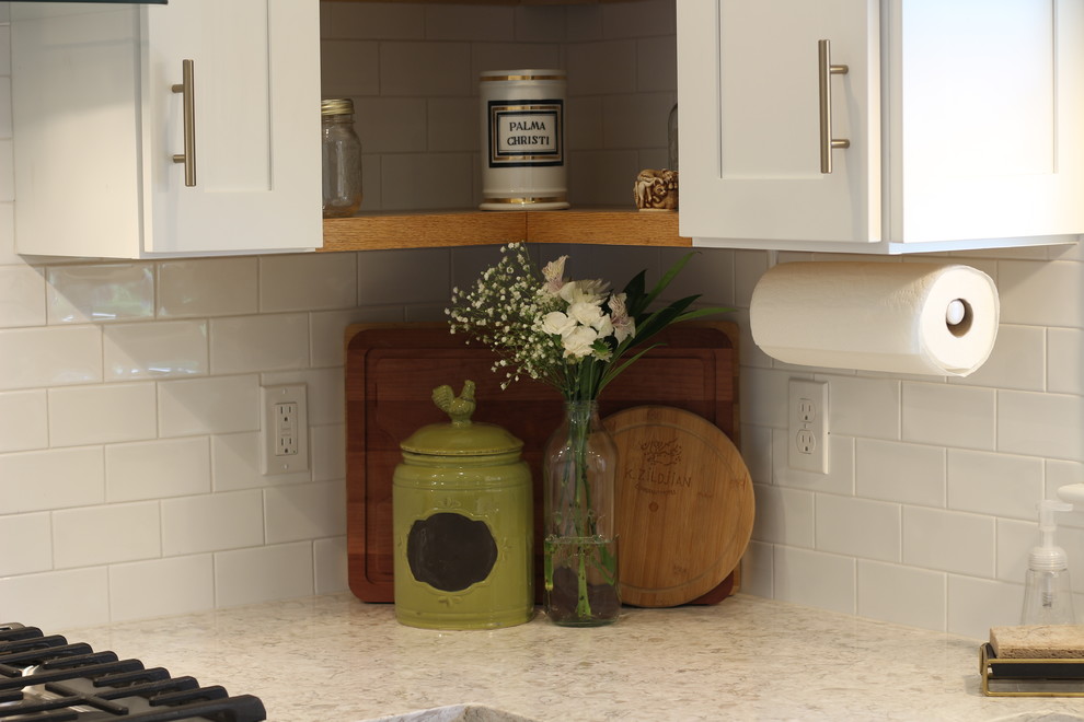 Inspiration for a mid-sized transitional u-shaped medium tone wood floor and brown floor enclosed kitchen remodel with a farmhouse sink, shaker cabinets, white cabinets, quartz countertops, white backsplash, subway tile backsplash, white appliances, no island and beige countertops