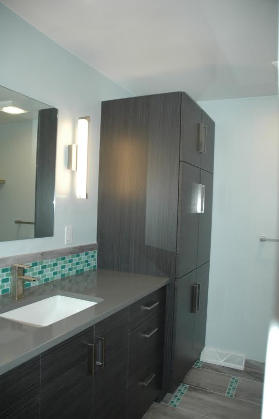 Mid-sized contemporary 3/4 bathroom in Other with flat-panel cabinets, dark wood cabinets, a two-piece toilet, blue tile, green tile, mosaic tile, blue walls, porcelain floors, an undermount sink, solid surface benchtops and multi-coloured floor.