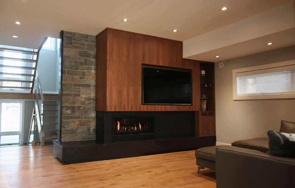 Mid-sized contemporary enclosed family room in Toronto with beige walls, light hardwood floors, a ribbon fireplace, a metal fireplace surround, a built-in media wall and brown floor.