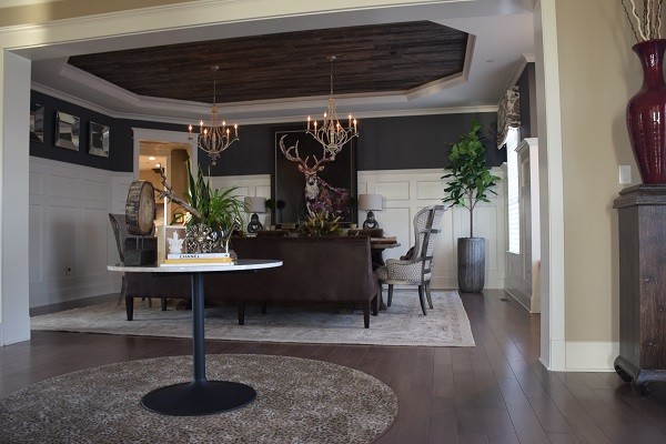 Example of a large mountain style medium tone wood floor foyer design in Baltimore with beige walls and a black front door