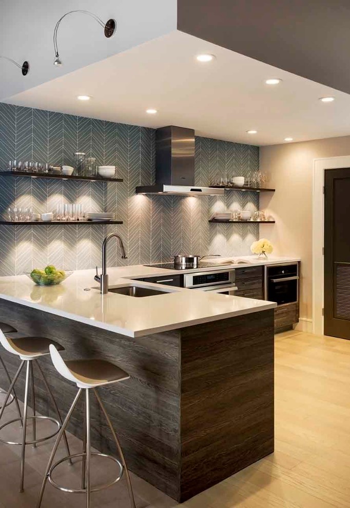This is an example of a mid-sized contemporary l-shaped kitchen in Boston with an undermount sink, flat-panel cabinets, dark wood cabinets, grey splashback, stainless steel appliances, light hardwood floors and a peninsula.