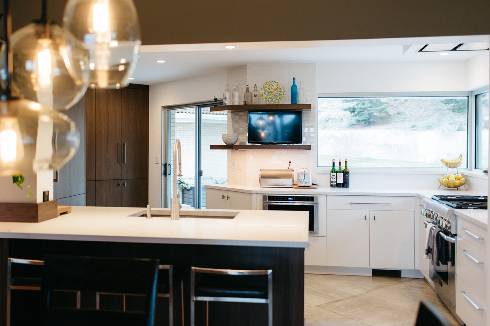 This is an example of a mid-sized modern single-wall eat-in kitchen in Salt Lake City with a drop-in sink, flat-panel cabinets, white cabinets, granite benchtops, white splashback, subway tile splashback, stainless steel appliances, ceramic floors and with island.