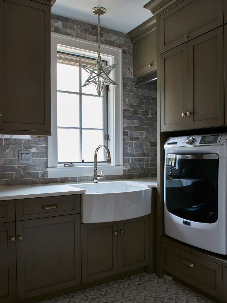 Foto på en funkis vita u-formad tvättstuga enbart för tvätt, med släta luckor, bruna skåp, bänkskiva i kvarts, flerfärgad stänkskydd, stänkskydd i mosaik, vita väggar, klinkergolv i keramik och grått golv