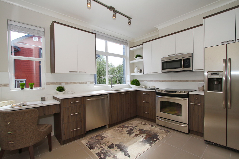Photo of a mid-sized contemporary l-shaped kitchen in Vancouver with a drop-in sink, flat-panel cabinets, white cabinets, quartz benchtops, white splashback, stainless steel appliances and ceramic floors.