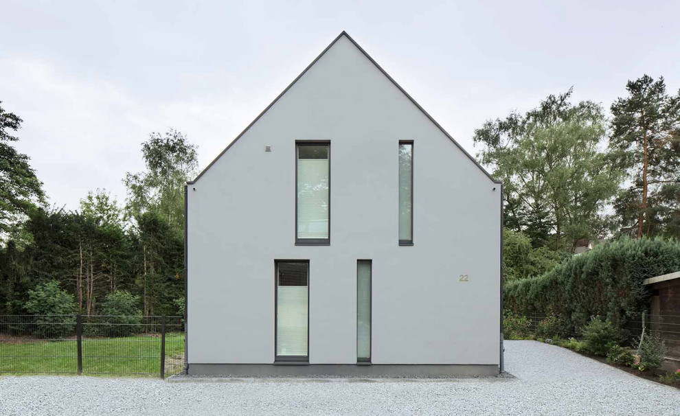 Mittelgroßes Modernes Einfamilienhaus mit Putzfassade, grauer Fassadenfarbe, Ziegeldach und schwarzem Dach in Dortmund