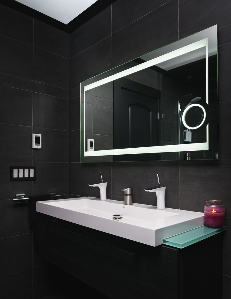 This is an example of a modern 3/4 bathroom in New York with flat-panel cabinets, black cabinets, an alcove shower, black tile, ceramic tile, black walls, a trough sink, glass benchtops, a double vanity and a floating vanity.