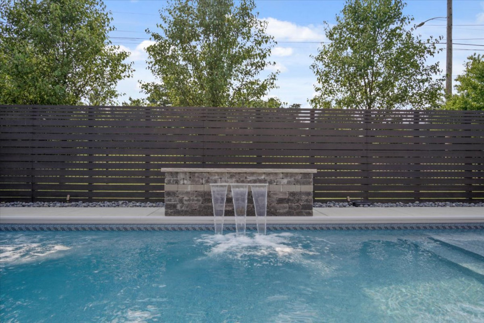 Idee per una piscina monocorsia moderna rettangolare di medie dimensioni e dietro casa con fontane e pavimentazioni in cemento