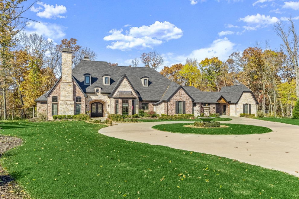 Design ideas for a large traditional two-storey brick house exterior in Other with a gable roof, a shingle roof and a black roof.