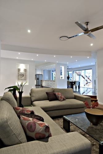 This is an example of a mid-sized modern formal open concept living room in Brisbane with light hardwood floors, a standard fireplace, a metal fireplace surround and a built-in media wall.